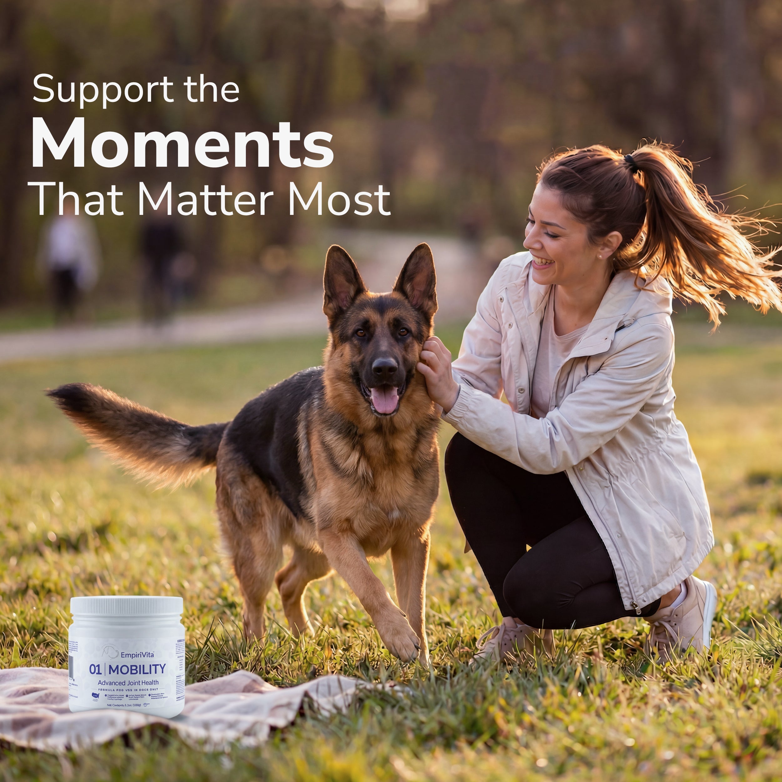 Woman petting German Shepherd in a park with EmpiriVita 01 Mobility joint health powder, supporting active moments